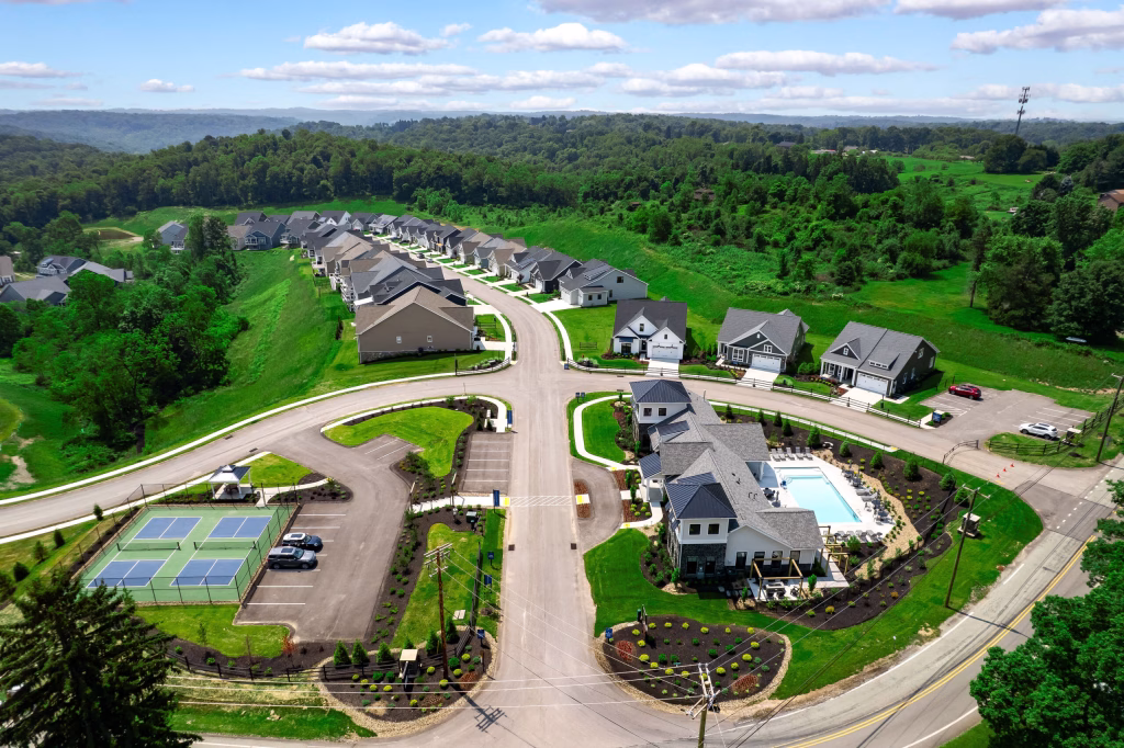 Modern commercial clubhouse aerial design featuring a pool and tennis courts by Wade Architecture.