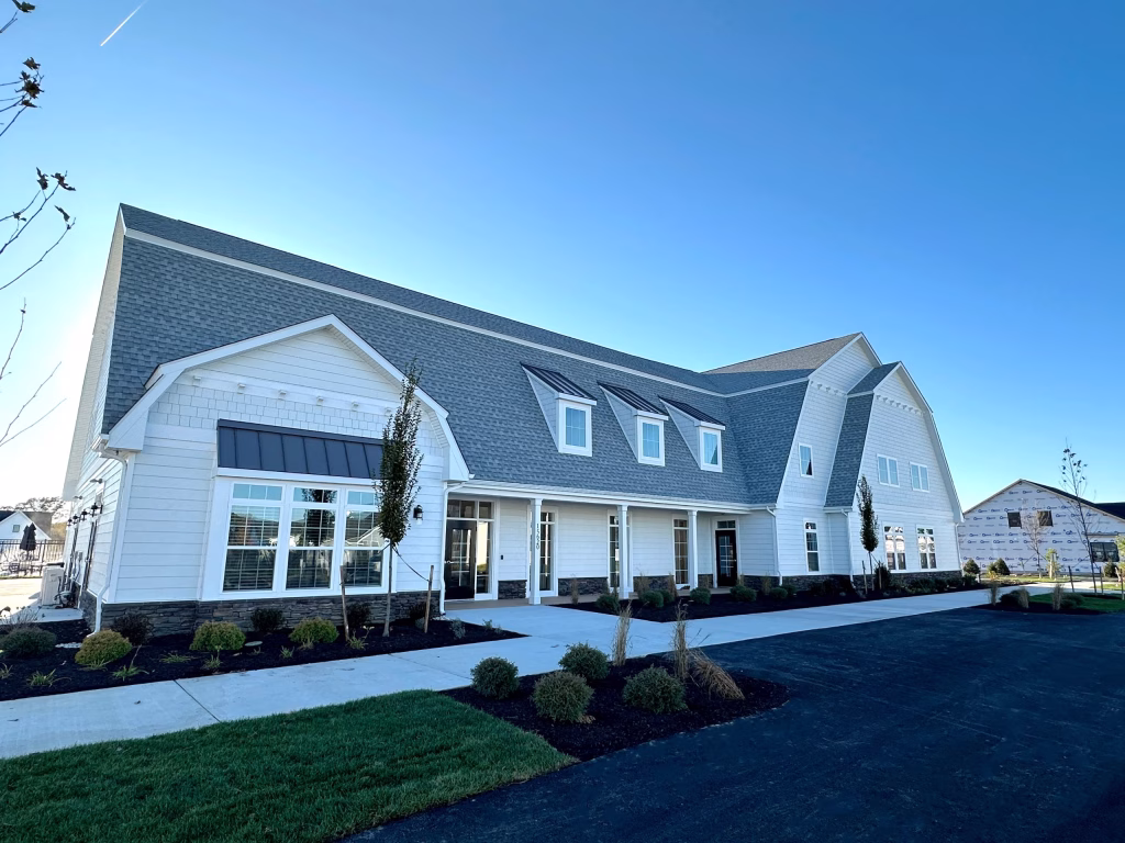 Modern commercial clubhouse exterior featuring white siding and a large pitched roof in Lewes, DE.