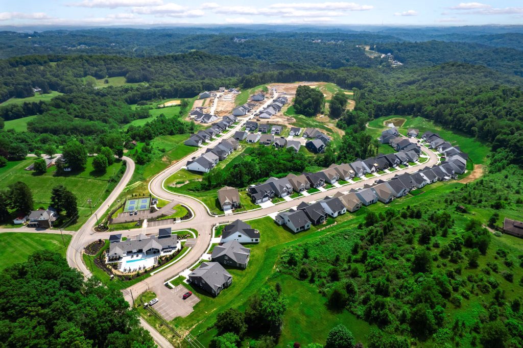 Aerial view of a modern residential neighborhood featuring a clubhouse, pool, and homes in Baden, PA.