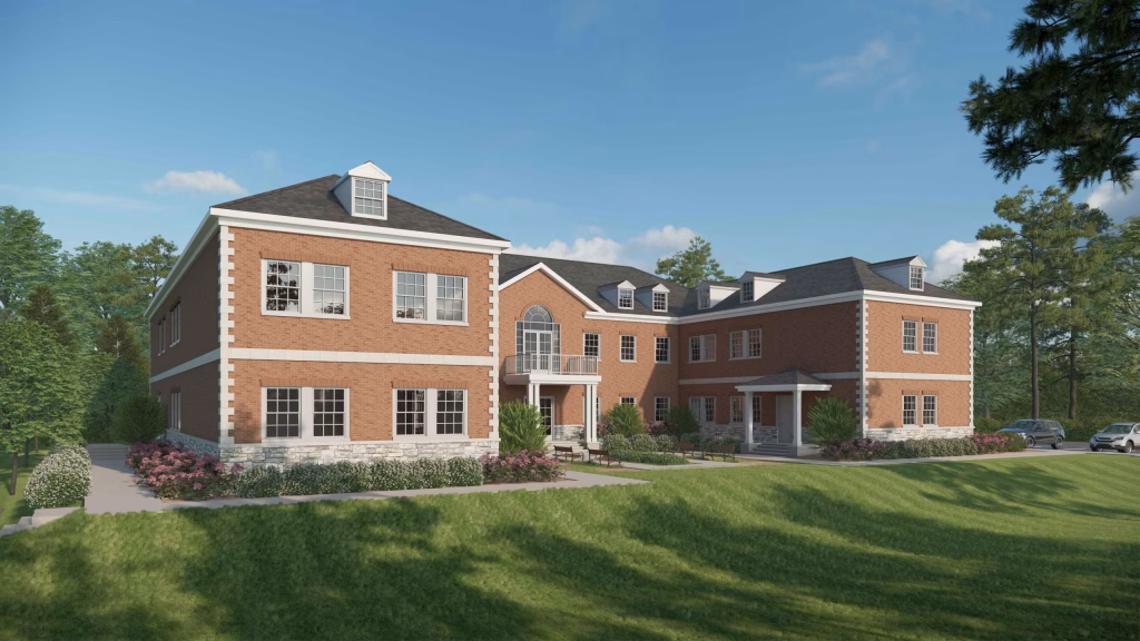 Traditional student housing exterior design with red brick and a central glass entrance by Wade Architecture.